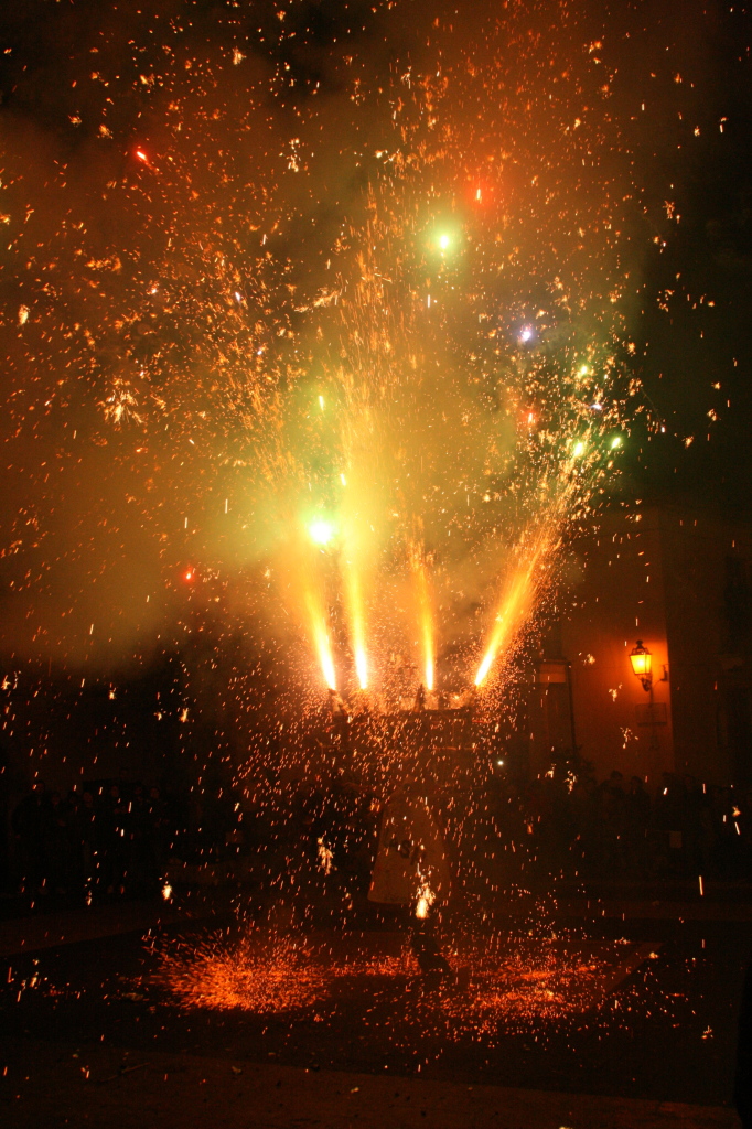 Un personaggio, rivestito da fuochi d'artificio, gira su se stesso nella pubblica piazza del paese in un'esplosione di petardi, razzi colorati e mortaretti