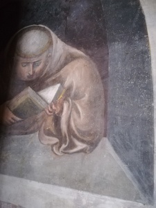 affresco con monaco immerso nella lettura